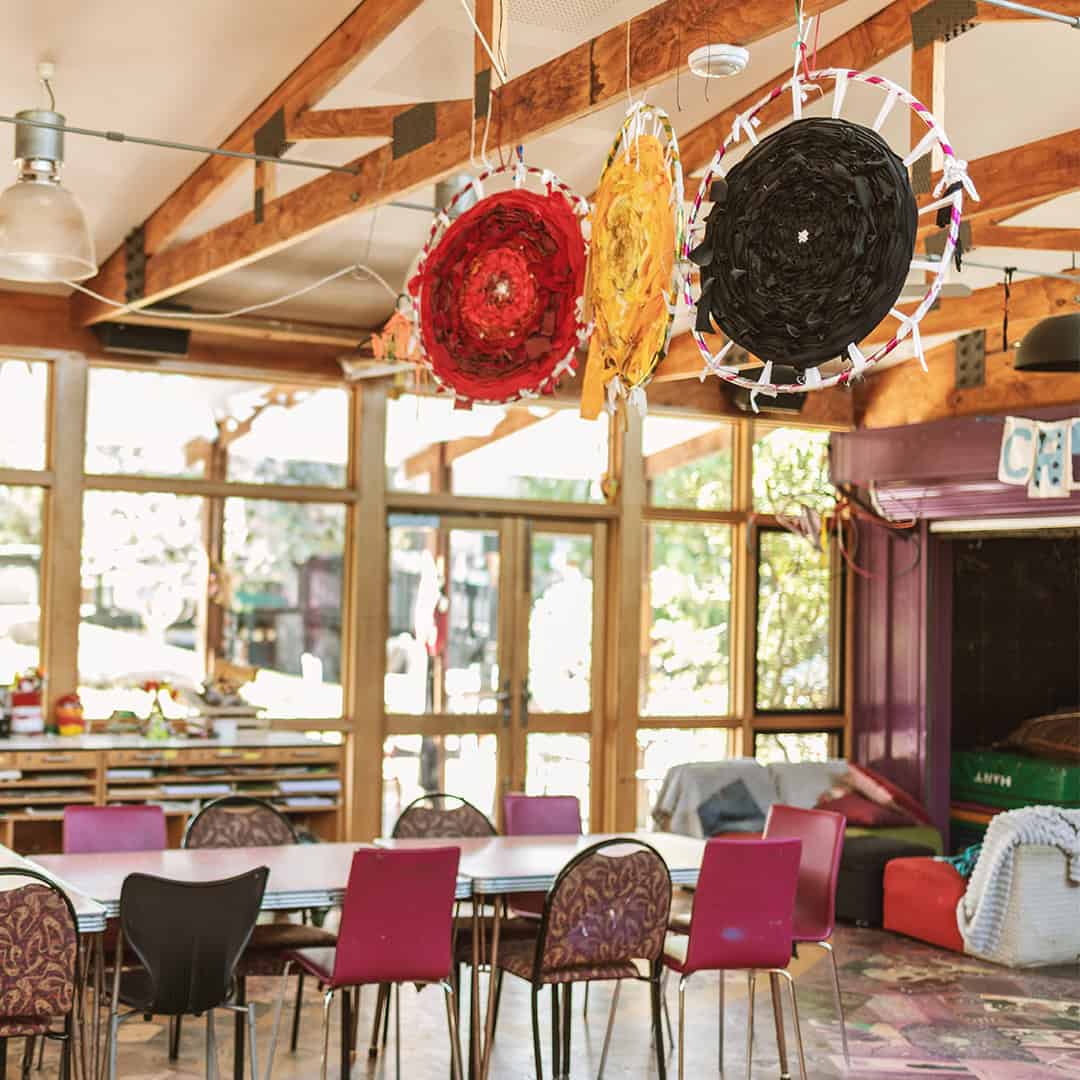 Venny Community Kitchen and Art Space Bright interior of The Venny community kitchen with colorful hanging art decorations.