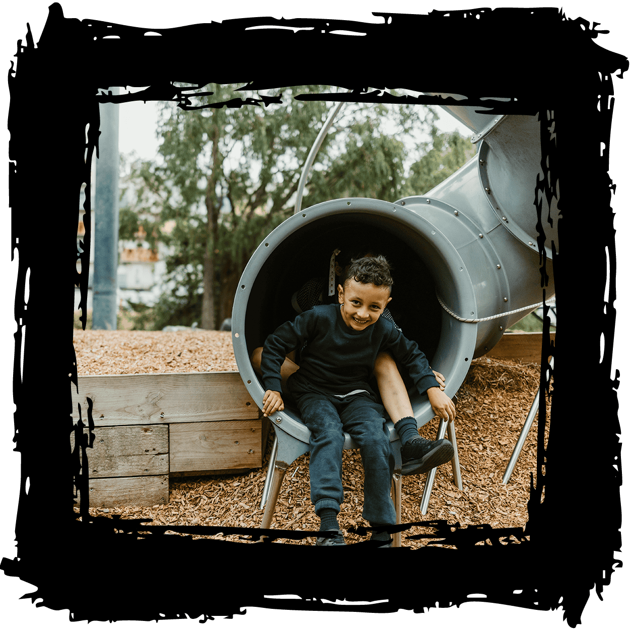 Child playing on a playground slide at The Venny community farm.